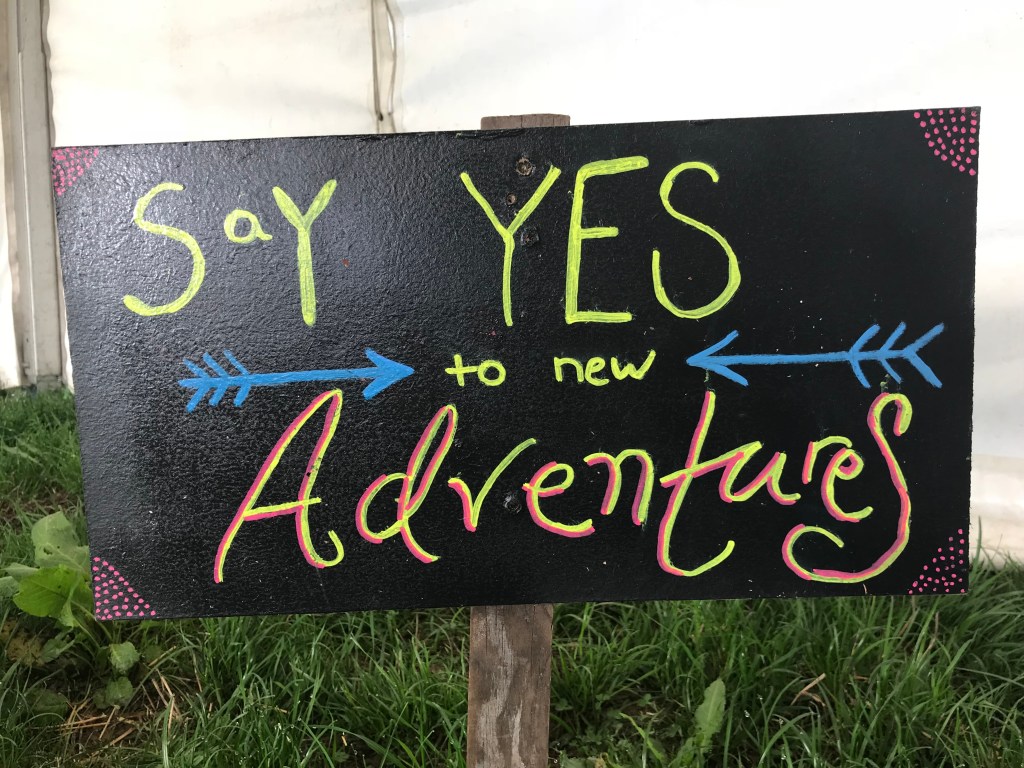 A chalk board sign "say YES to new Adventures"