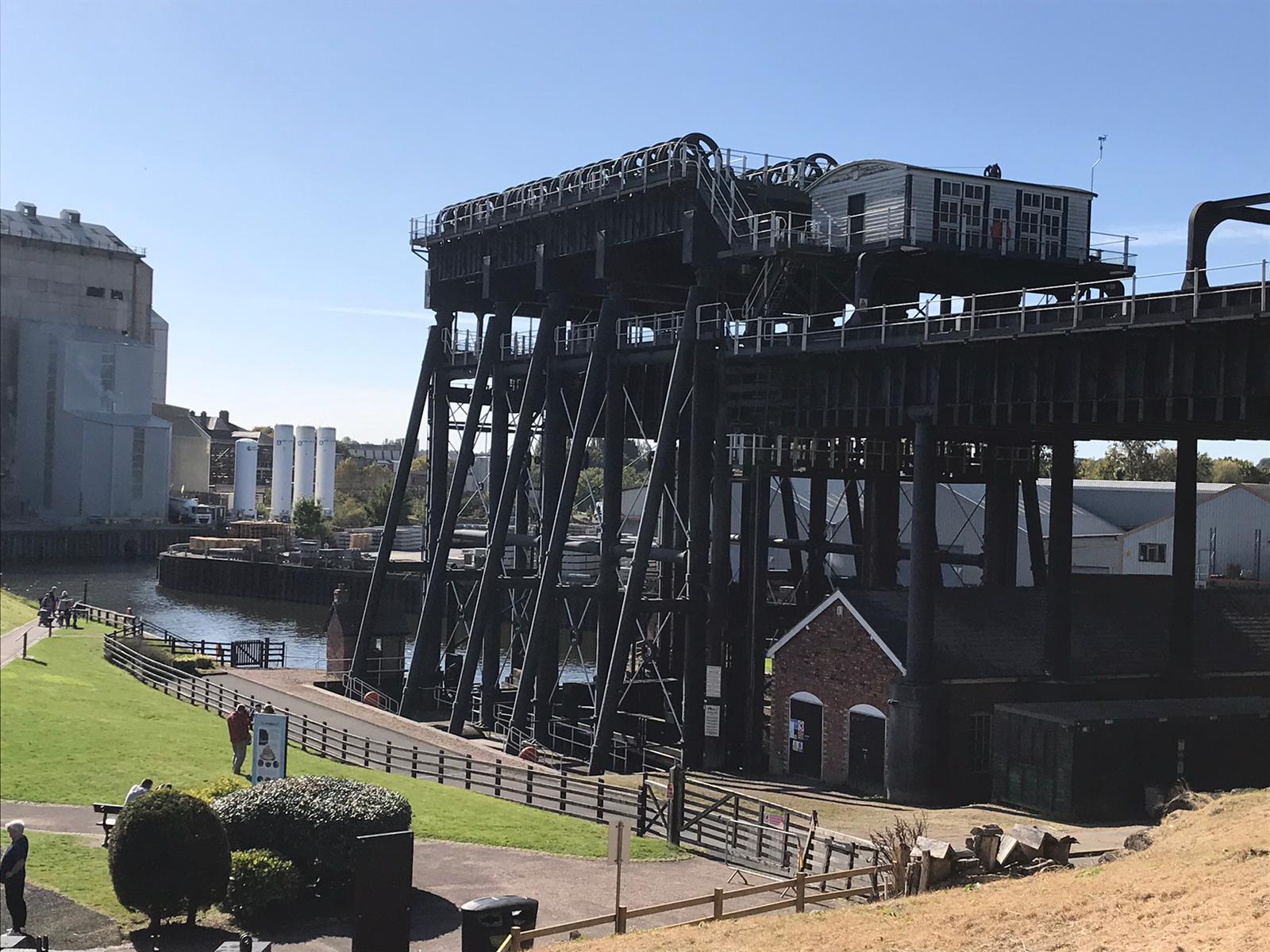 A large black steel construction with two moving water-filled containers for carrying boats.