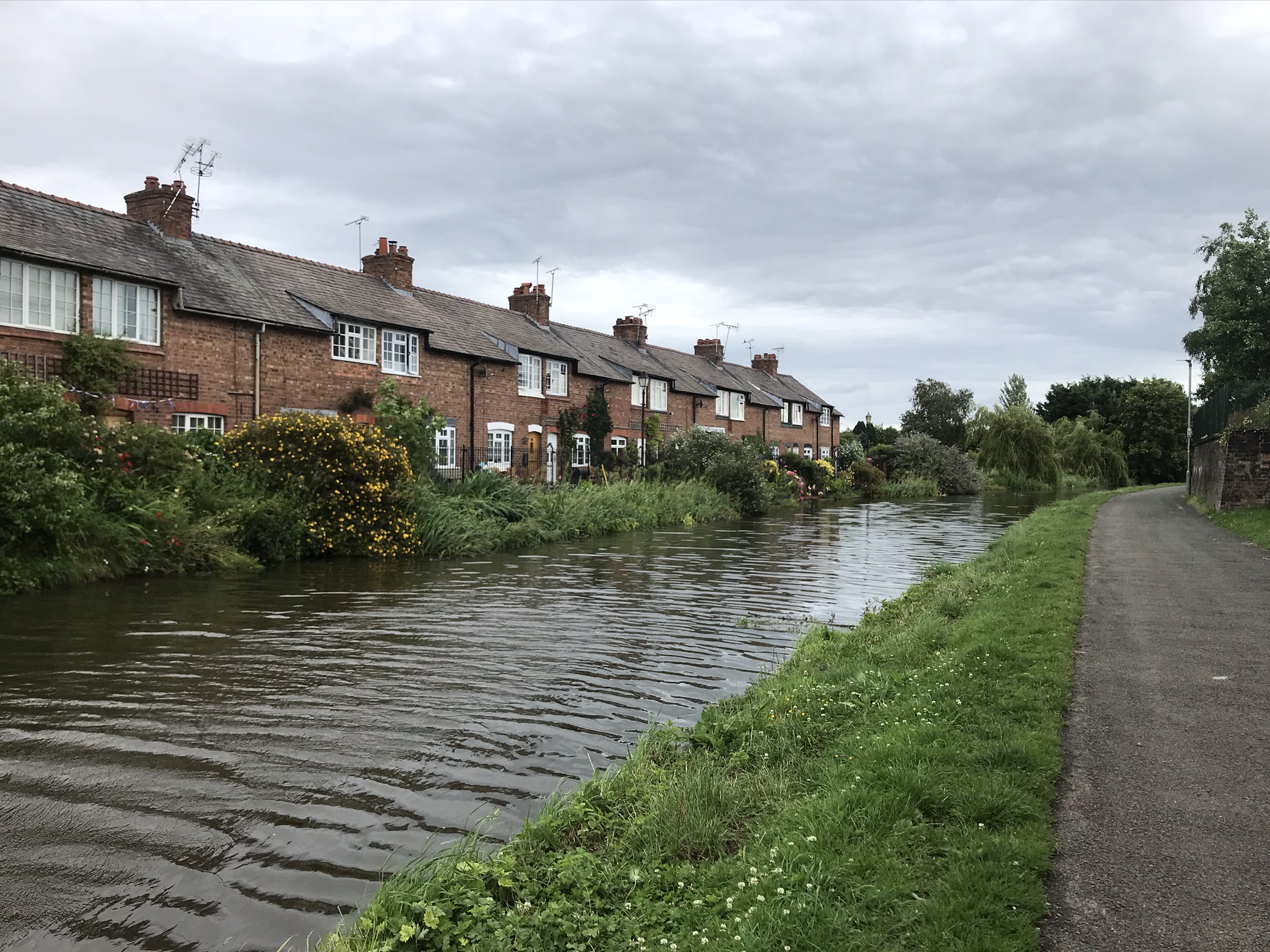 A row of brick cottages backing onto the canal with a two path on the opposite bank