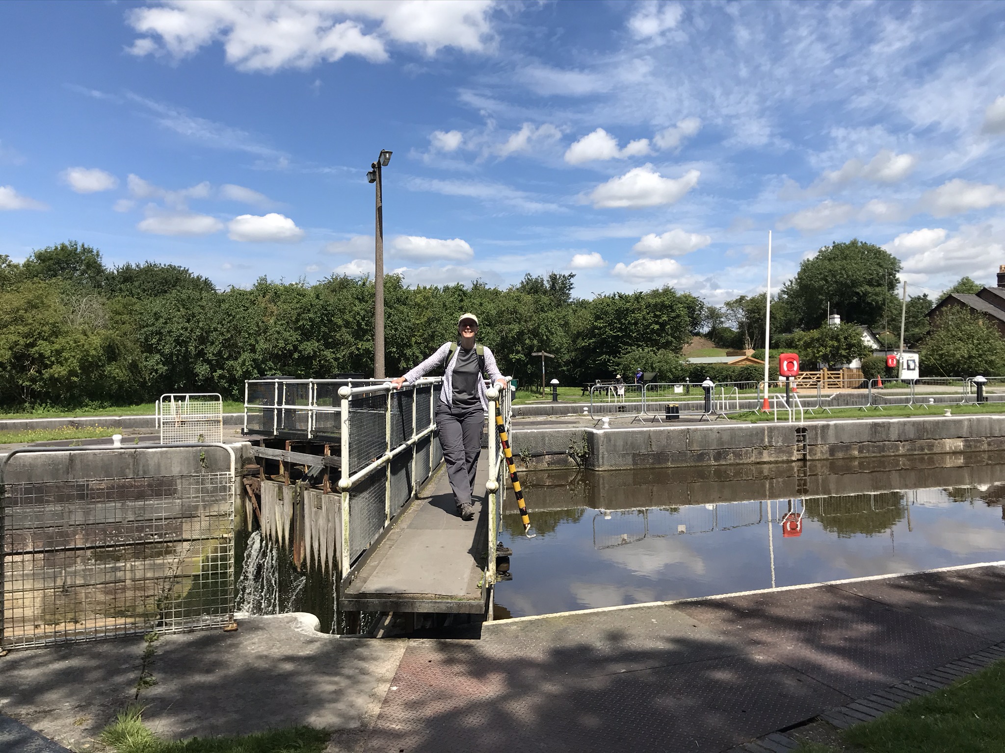 A walker stands on top of very big lock gates