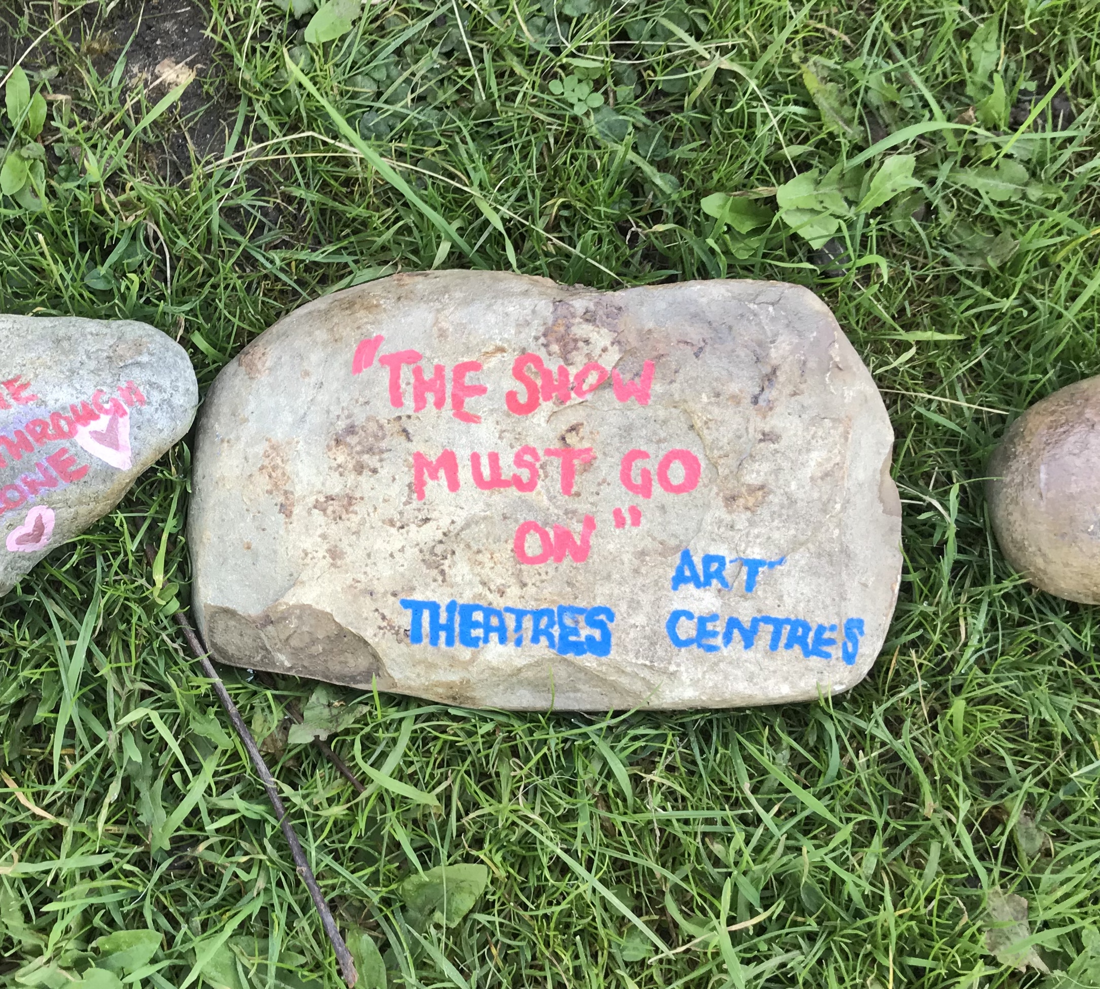 a stone with "the show must go on" "Theatres" and "Art centres" painted on it.