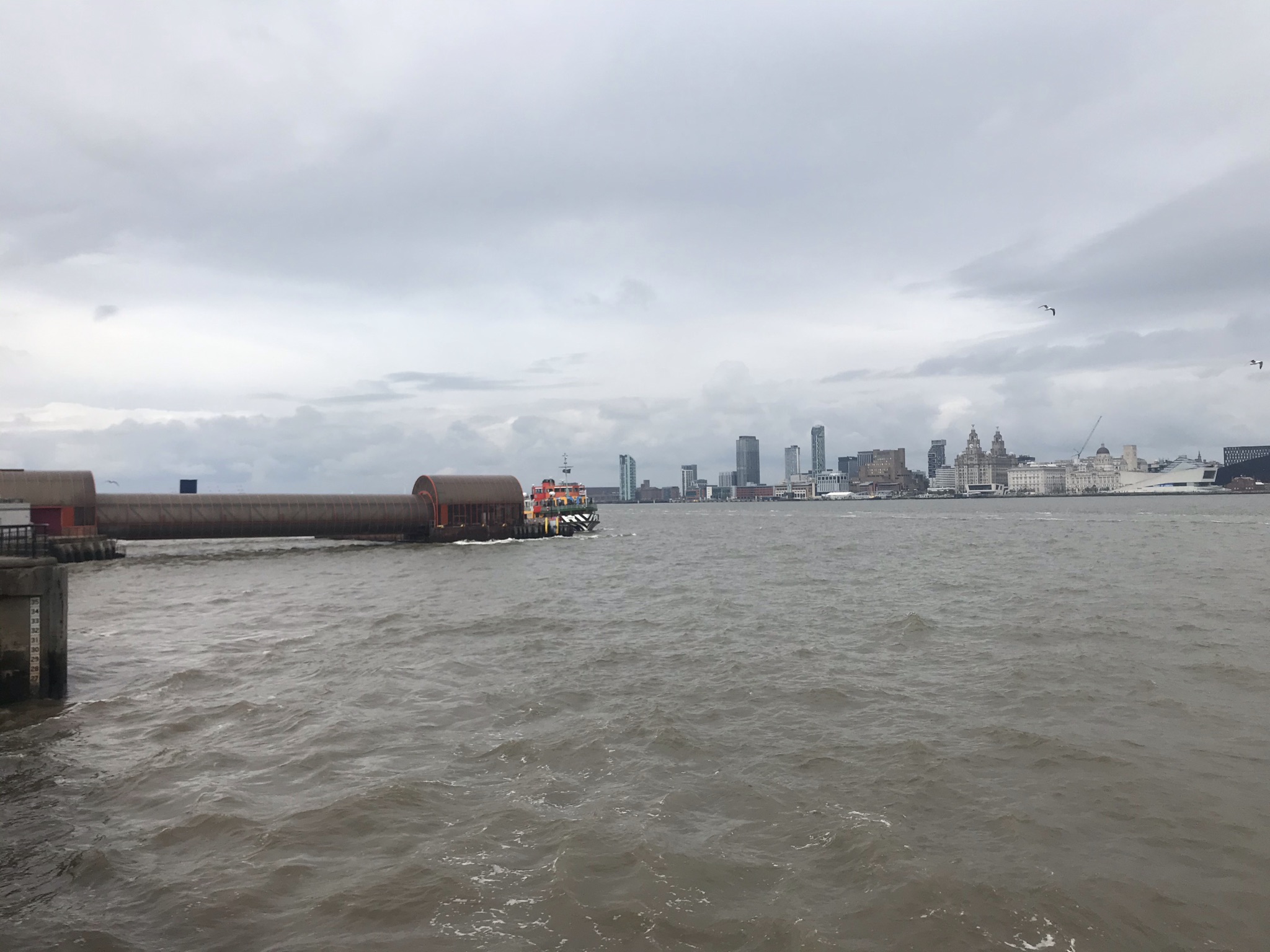 The brightly painted Mersey Ferry with Liverpool city in the distance