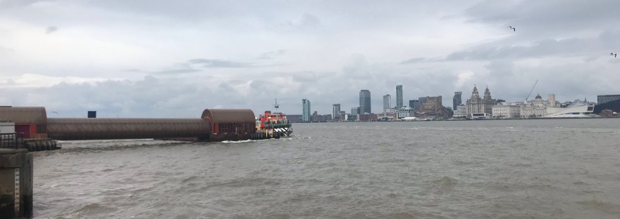 The brightly painted Mersey Ferry with Liverpool city in the distance