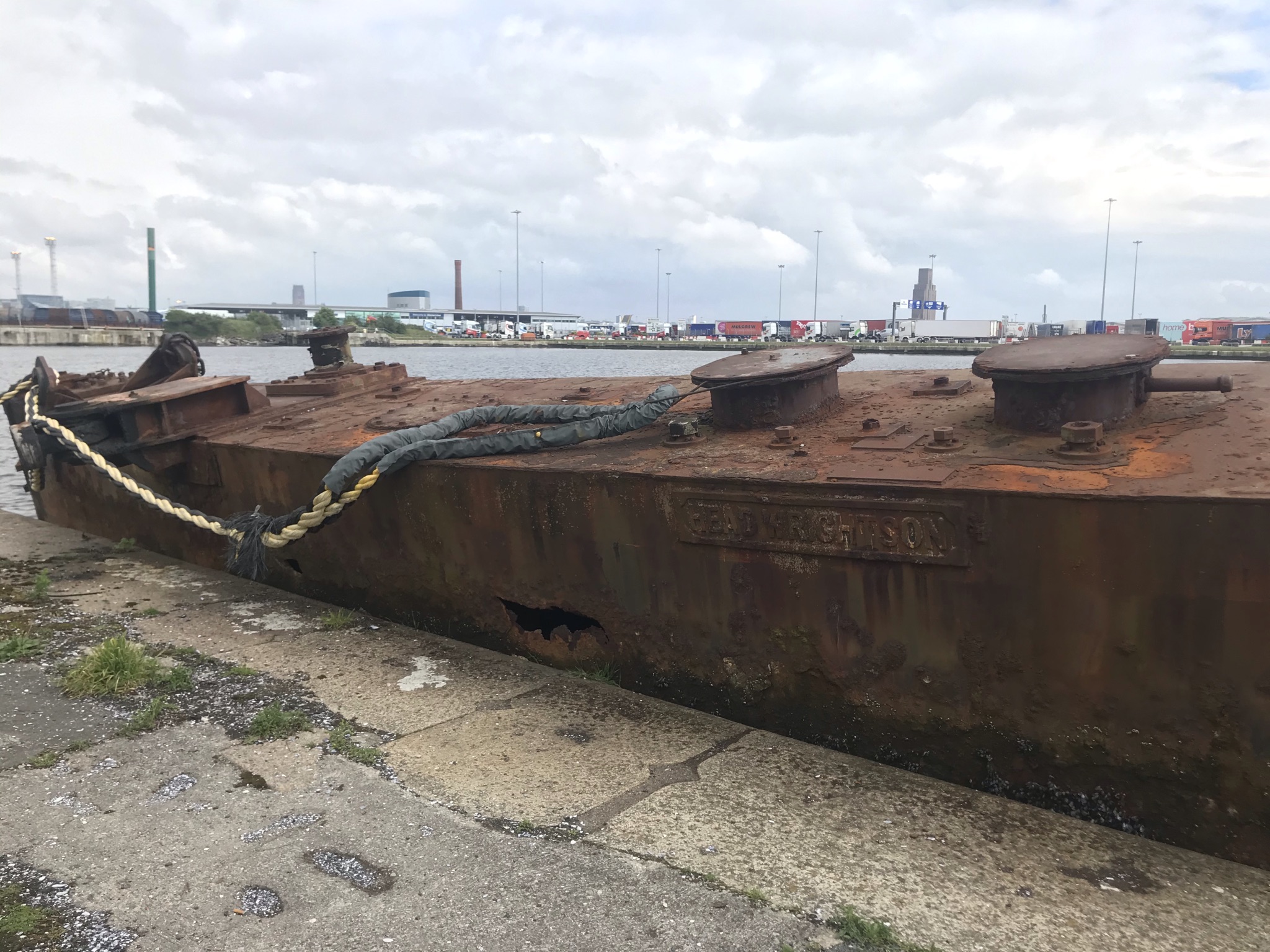 A rusty boat with docks in the background
