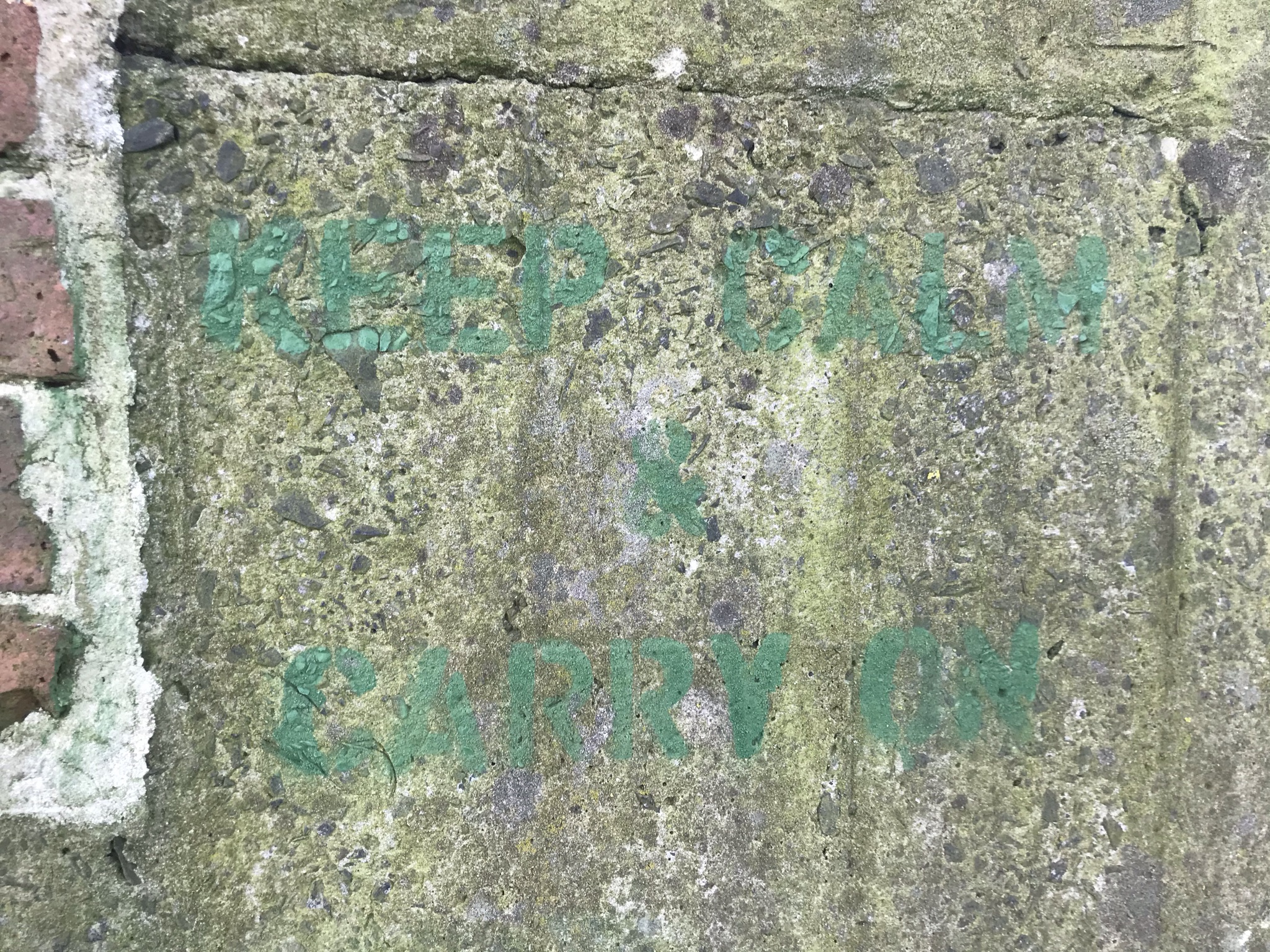 "keep call & carry on" in faint green stencil on concrete