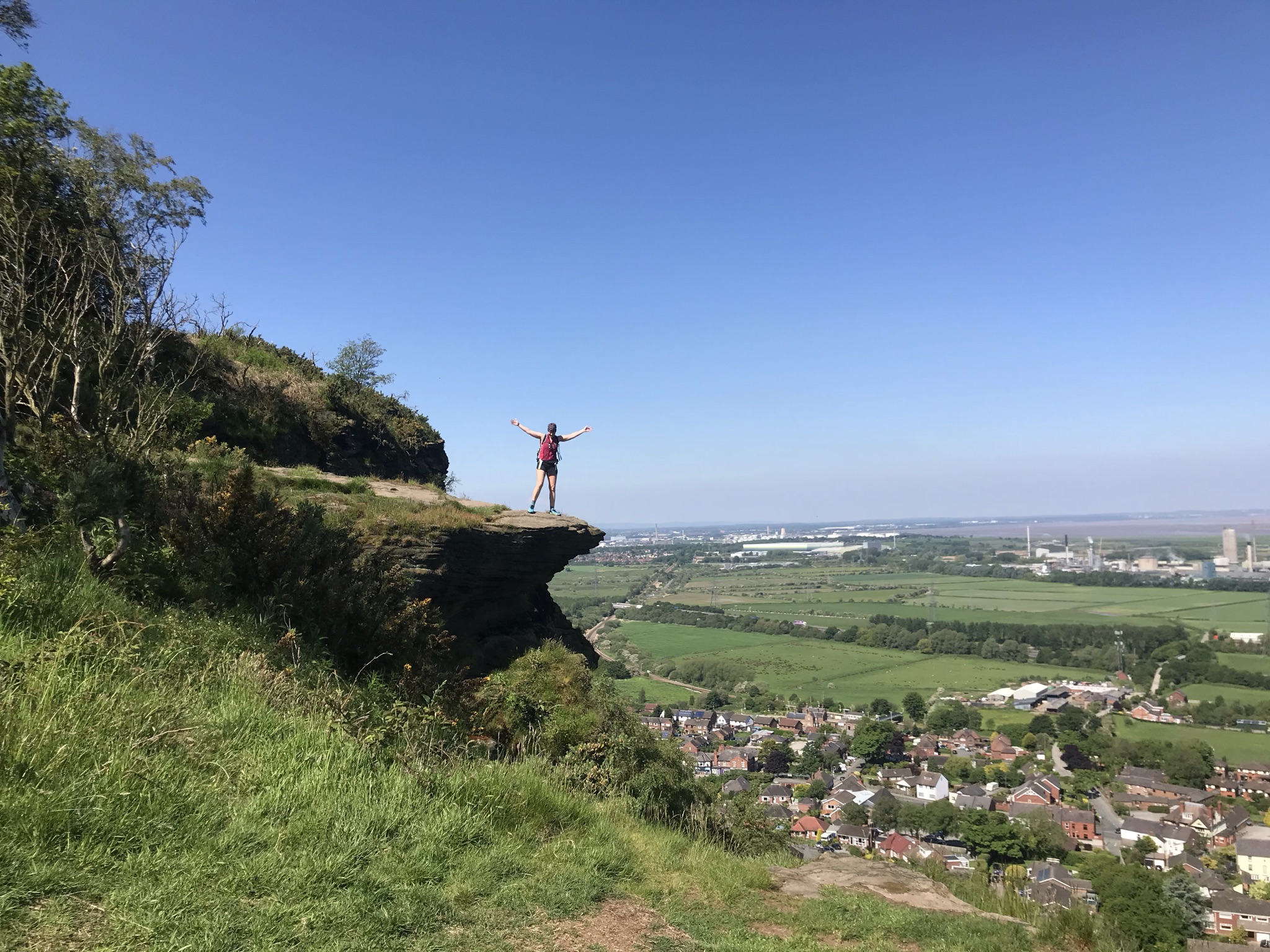 Sarah stands on a rock ledge with long views to the horizon