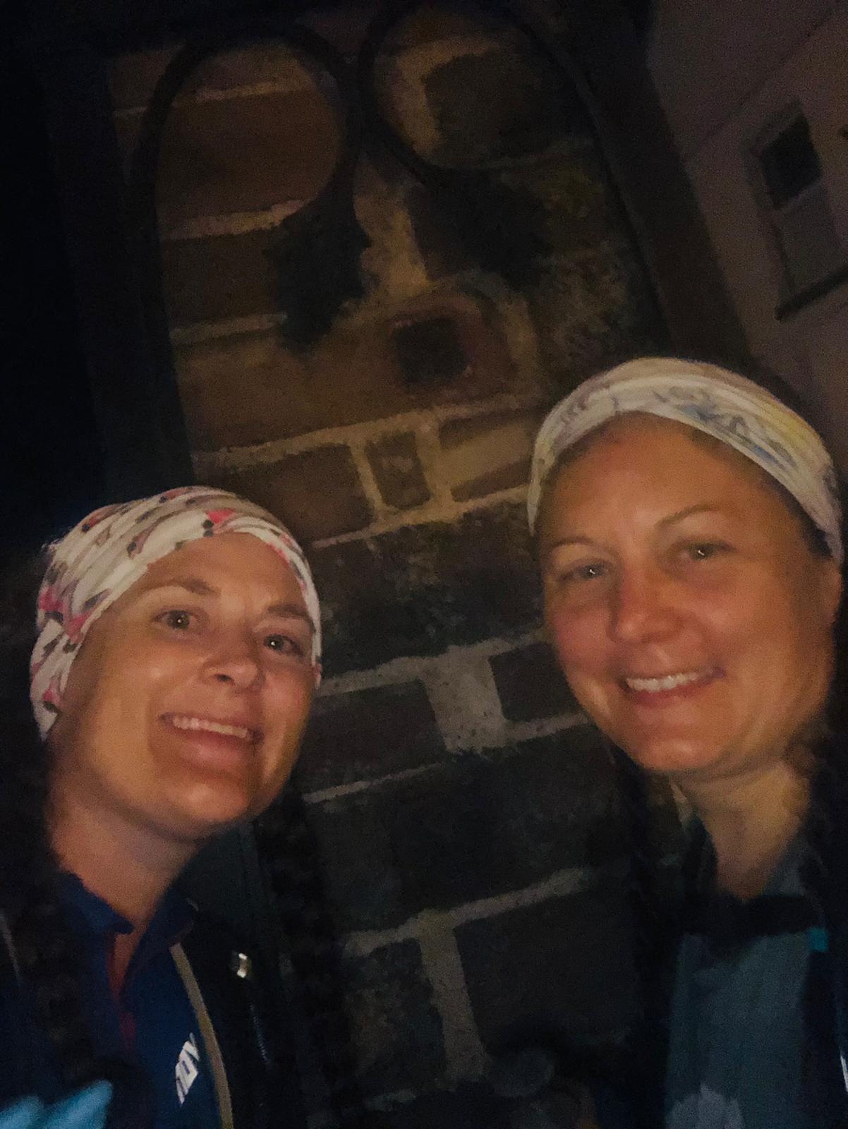 A grainy night photo of Sarah and Ellen at the pillar in Frodsham