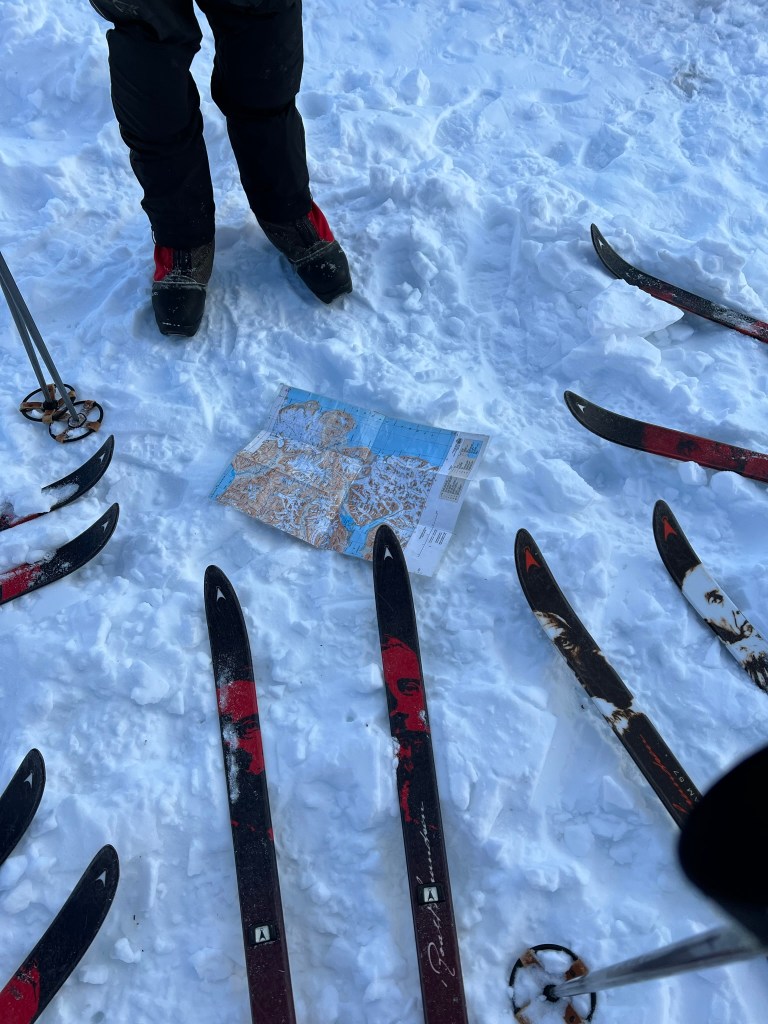 A circle of skis around a map of Svalbard on the snow.