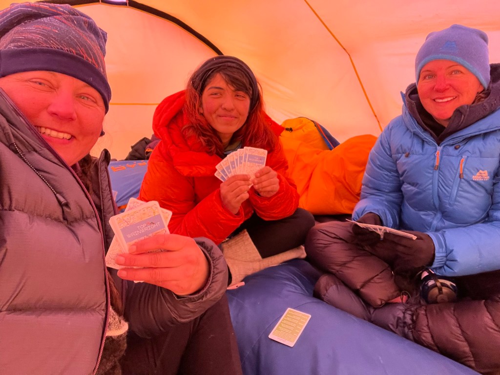 A selfie of me and my tent buddies sat on our sleeping bag playing cards